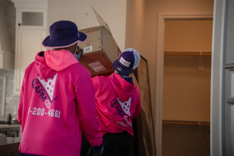 Two movers carrying boxes into a residential home during a Council Bluffs to Omaha move