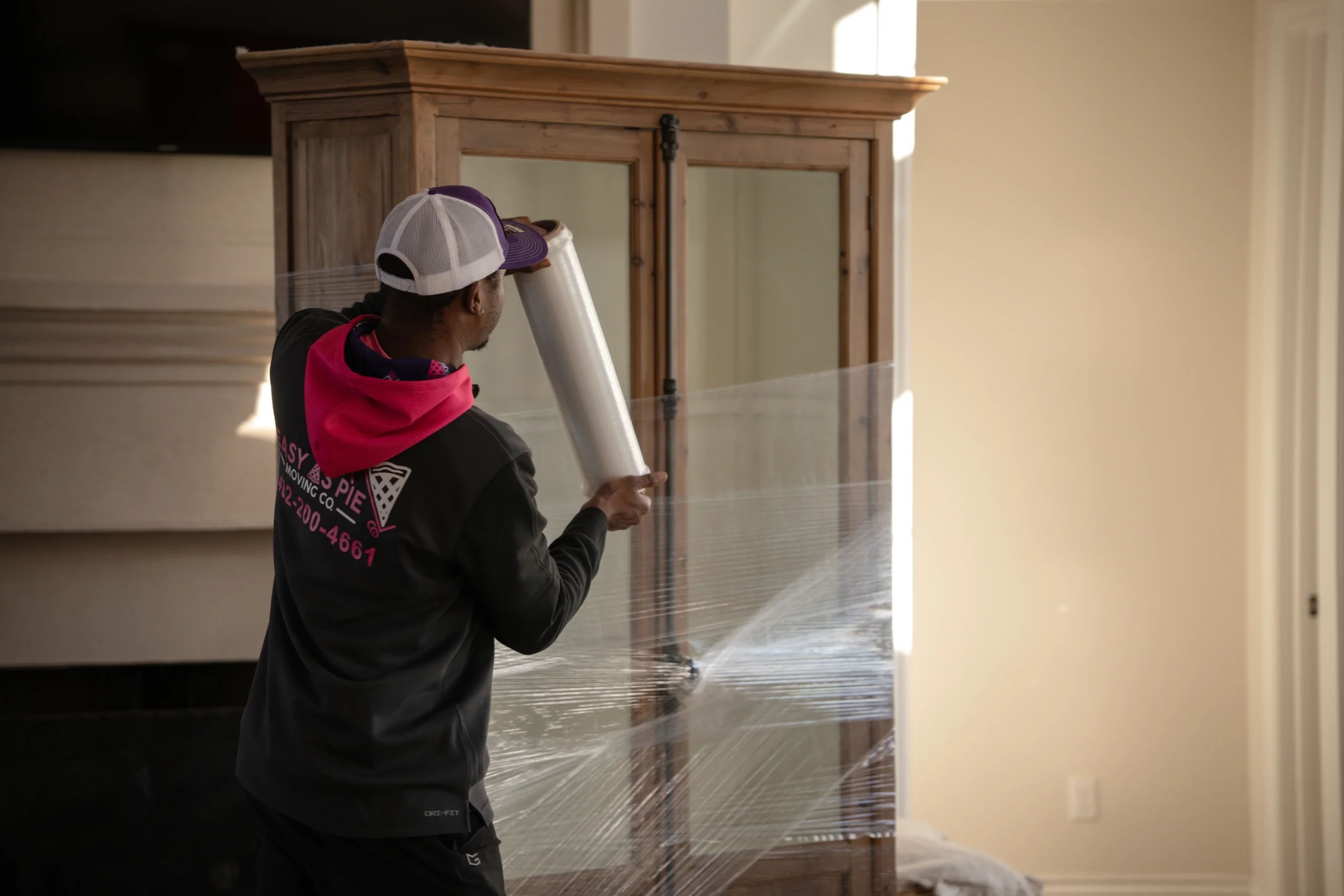 Easy As Pie mover wrapping furniture inside a home