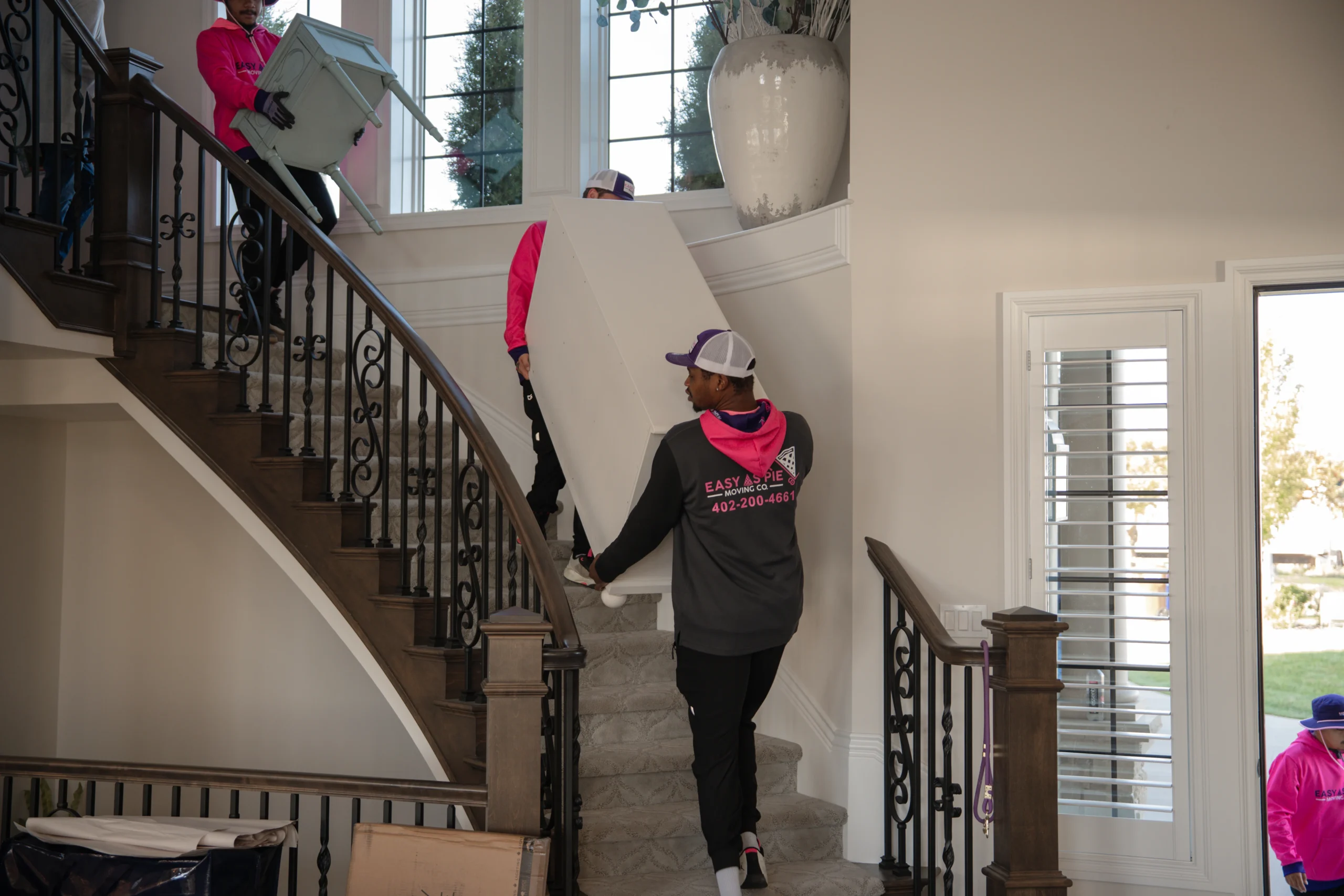 Easy As Pie mover carrying furniture down a staircase