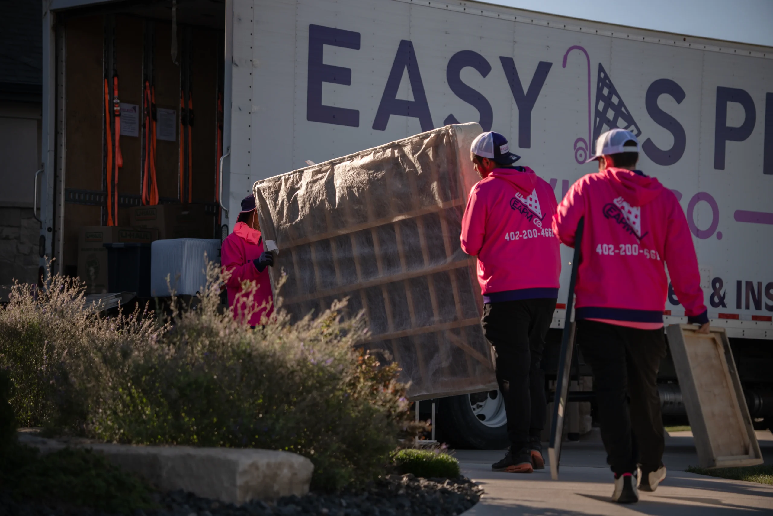 Easy As Pie movers loading a wrapped mattress into the truck