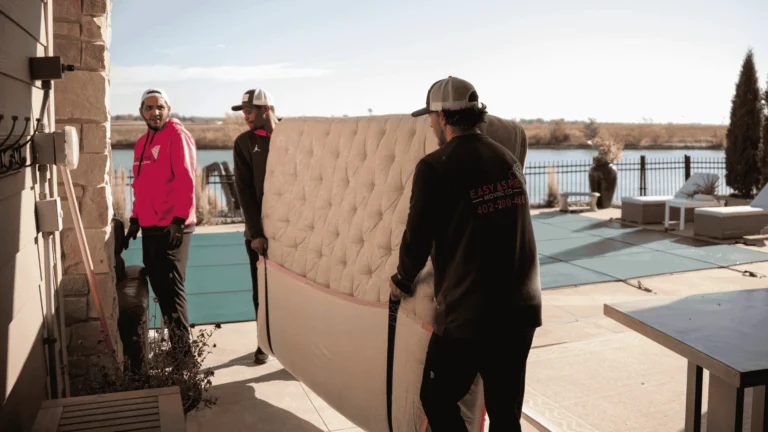 Easy As Pie movers carrying a headboard outside a lake home