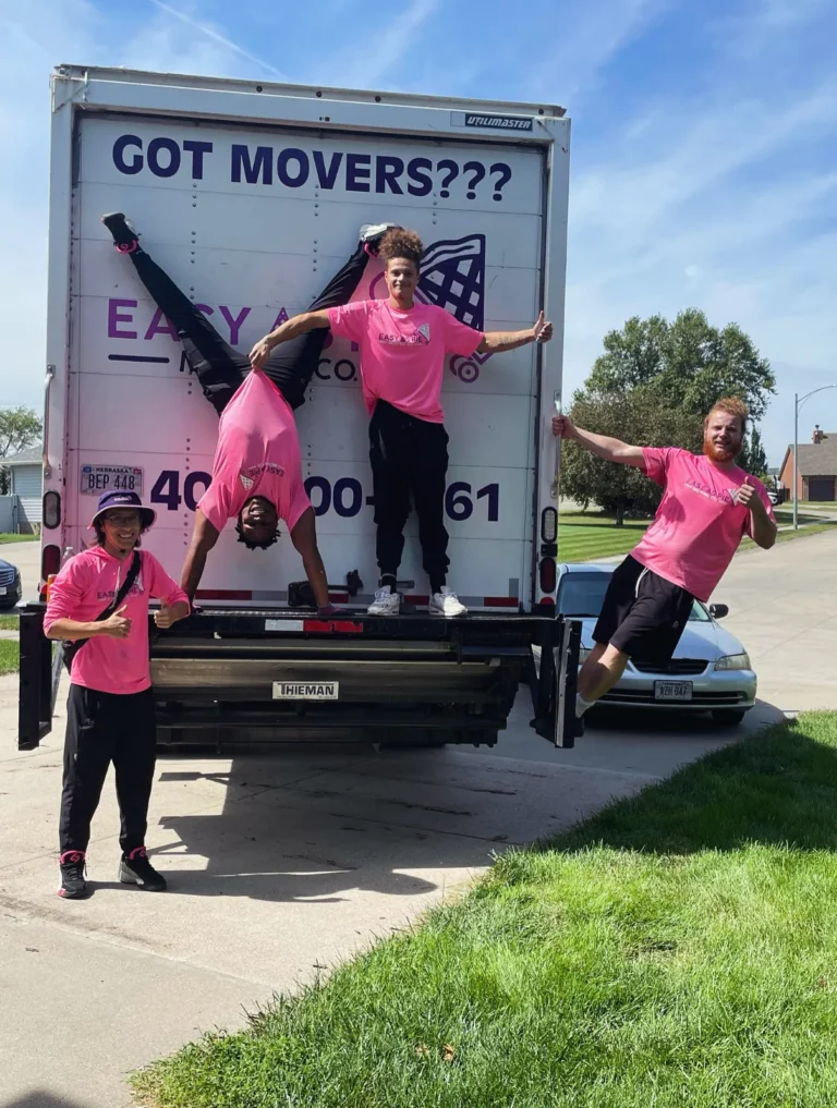 Three Easy As Pie movers posing on the back of a moving truck