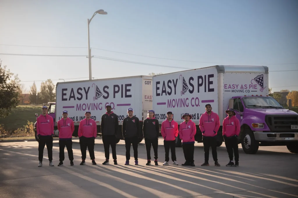 Easy As Pie Moving Co. crew lined up in front of two moving trucks