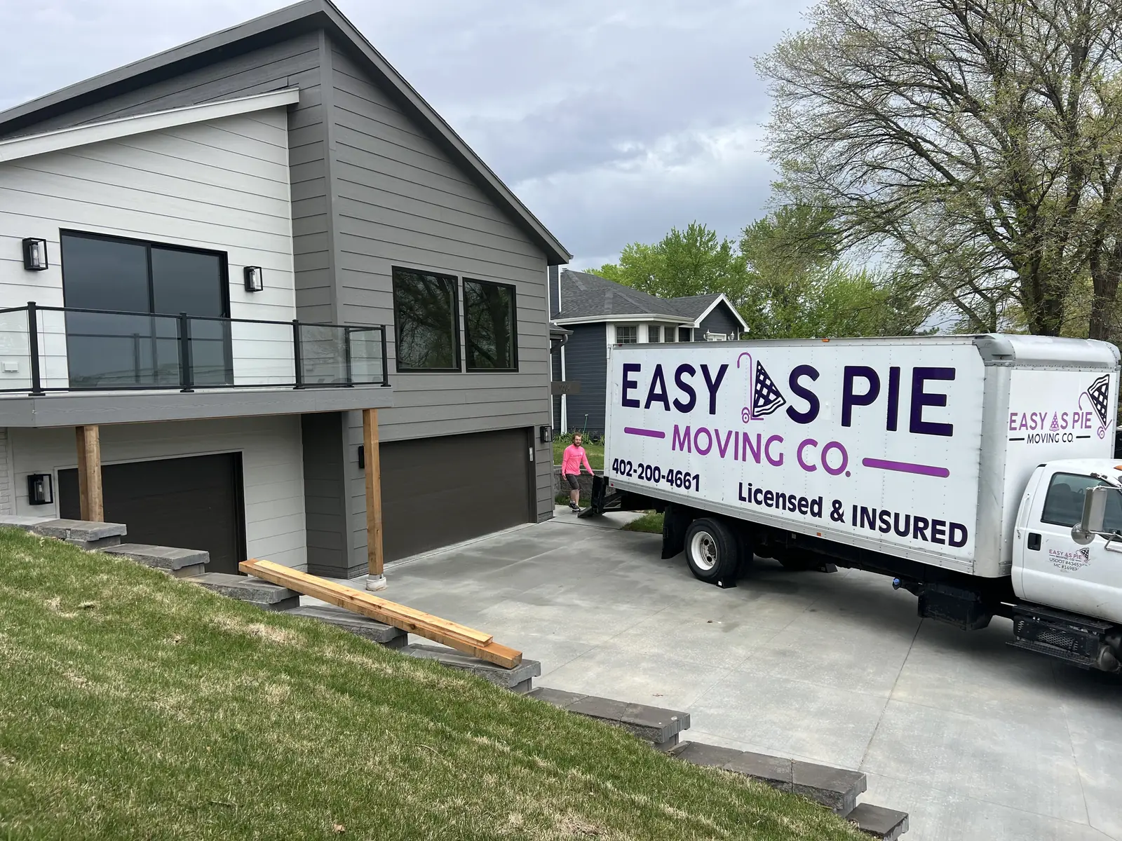 Easy As Pie Moving Co. truck in the driveway of a modern home