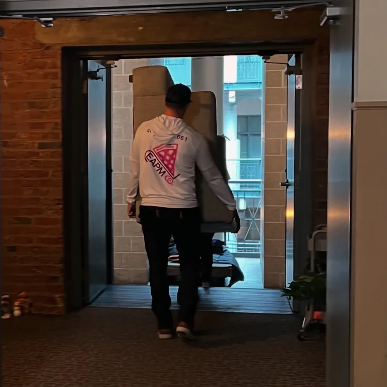 Easy As Pie mover carrying a box through a building entrance