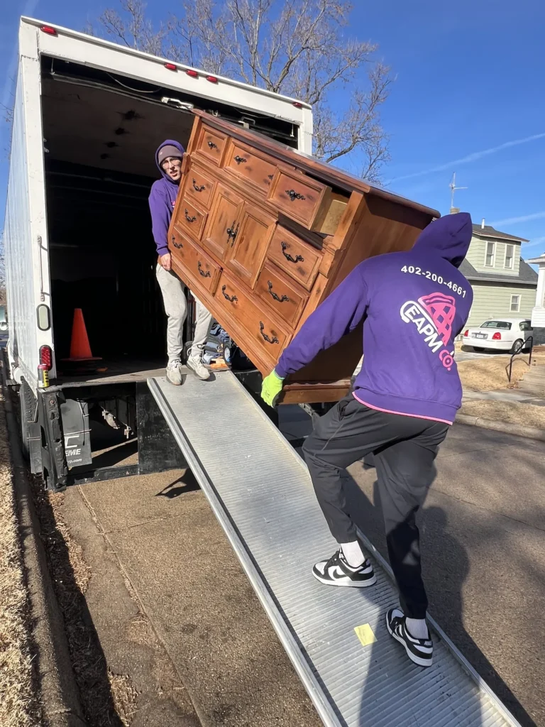 Easy As Pie mover carrying a wooden dresser down the truck ramp