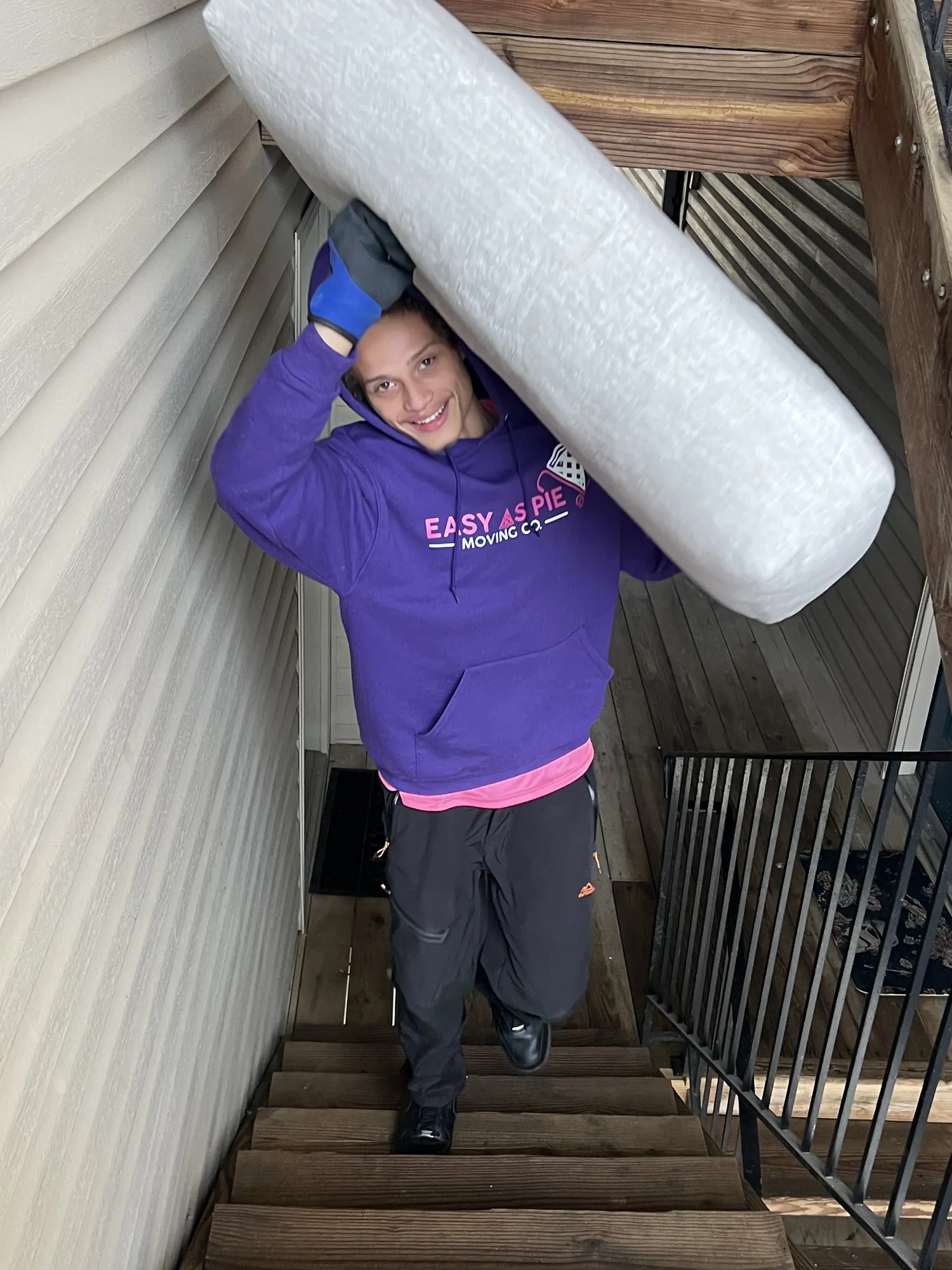 Easy As Pie mover carrying a wrapped mattress up a walk-up stairwell