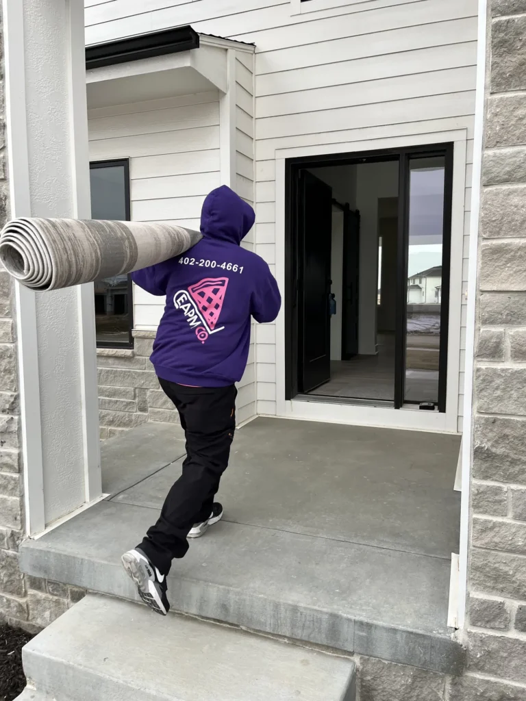 Easy As Pie mover carrying a rolled rug into a home