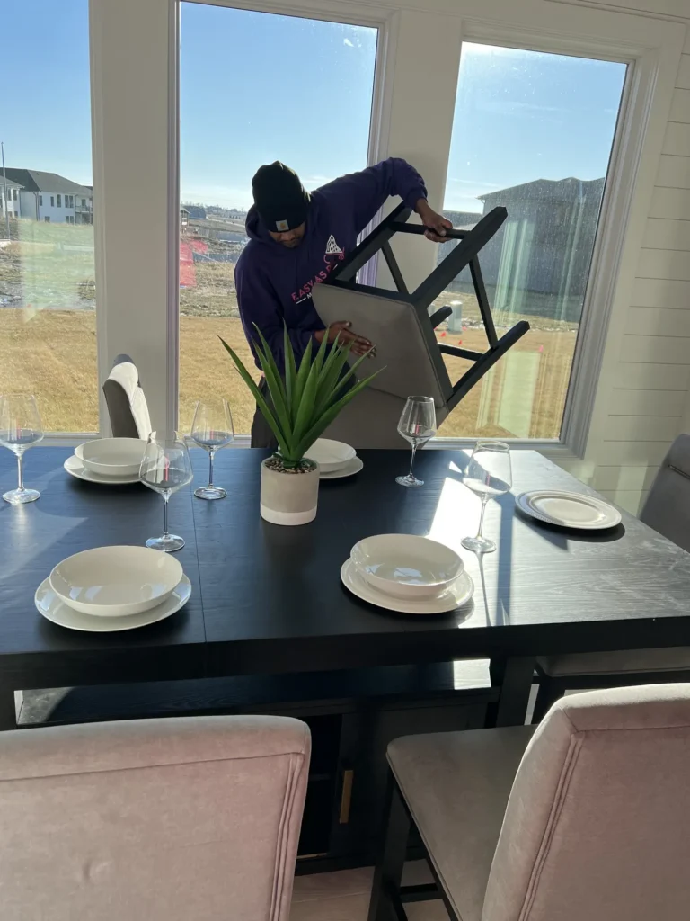 Easy As Pie mover setting up dining room furniture in a new home
