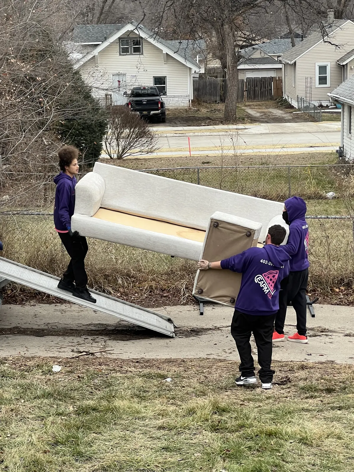 Easy As Pie movers carrying a couch down a truck ramp