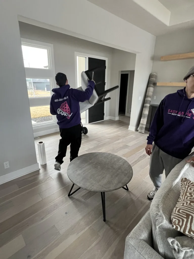 Easy As Pie movers carrying furniture through a bright living room