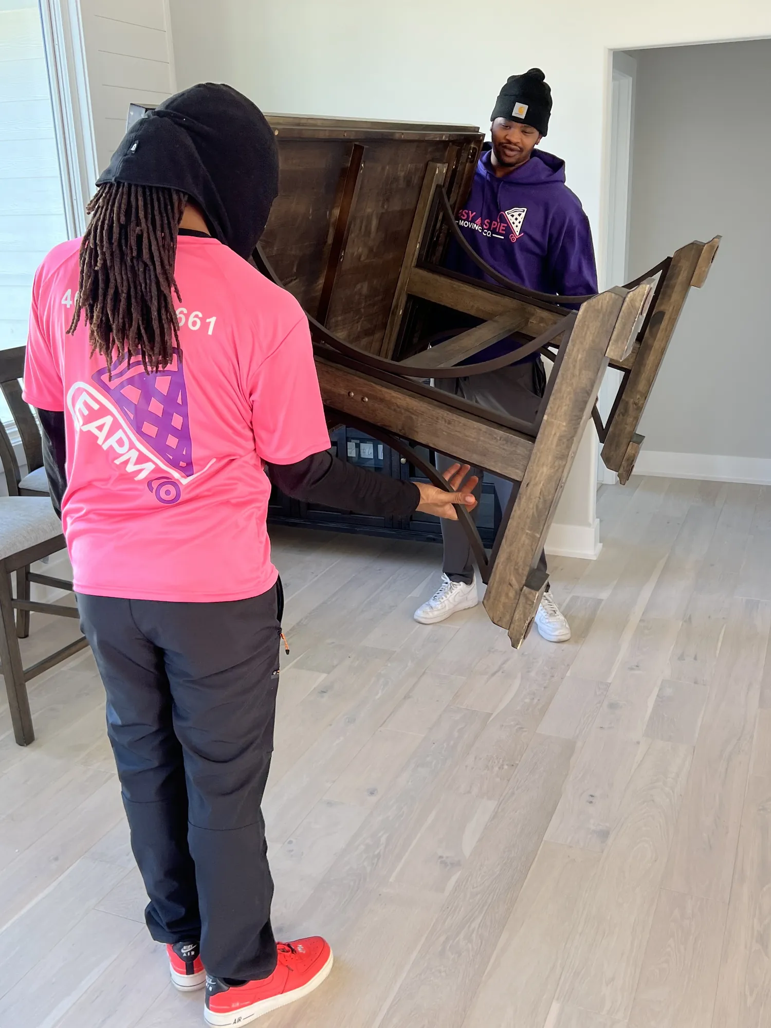 Easy As Pie movers carrying a heavy wooden piece of furniture