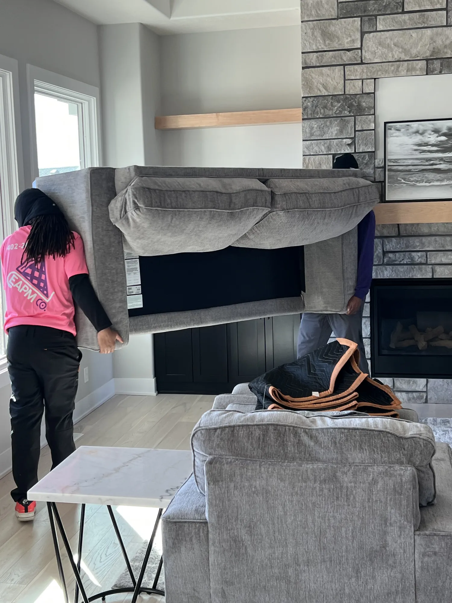 Easy As Pie movers carrying a sectional sofa through a living room