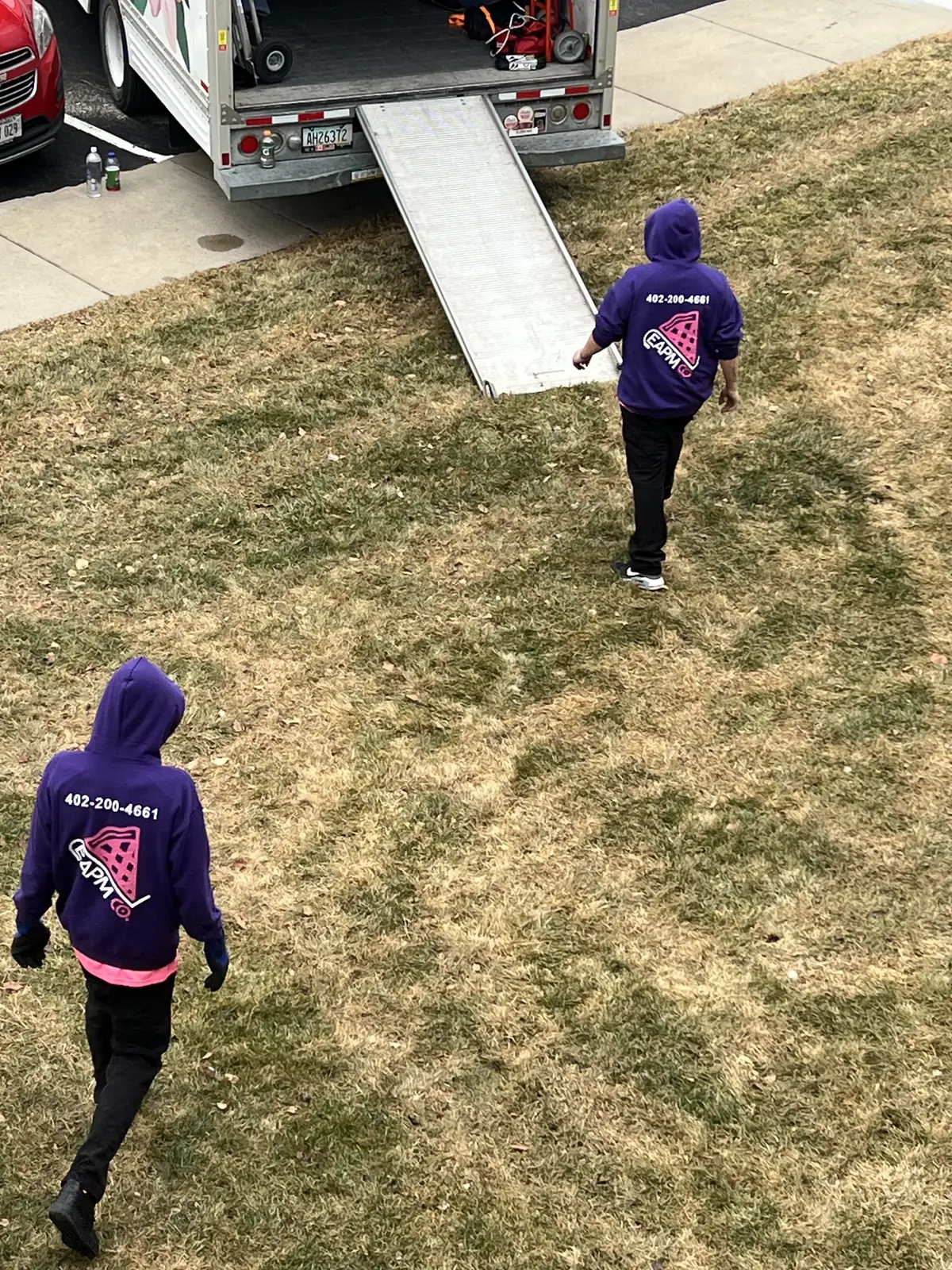 Easy As Pie movers heading across a yard to the moving truck