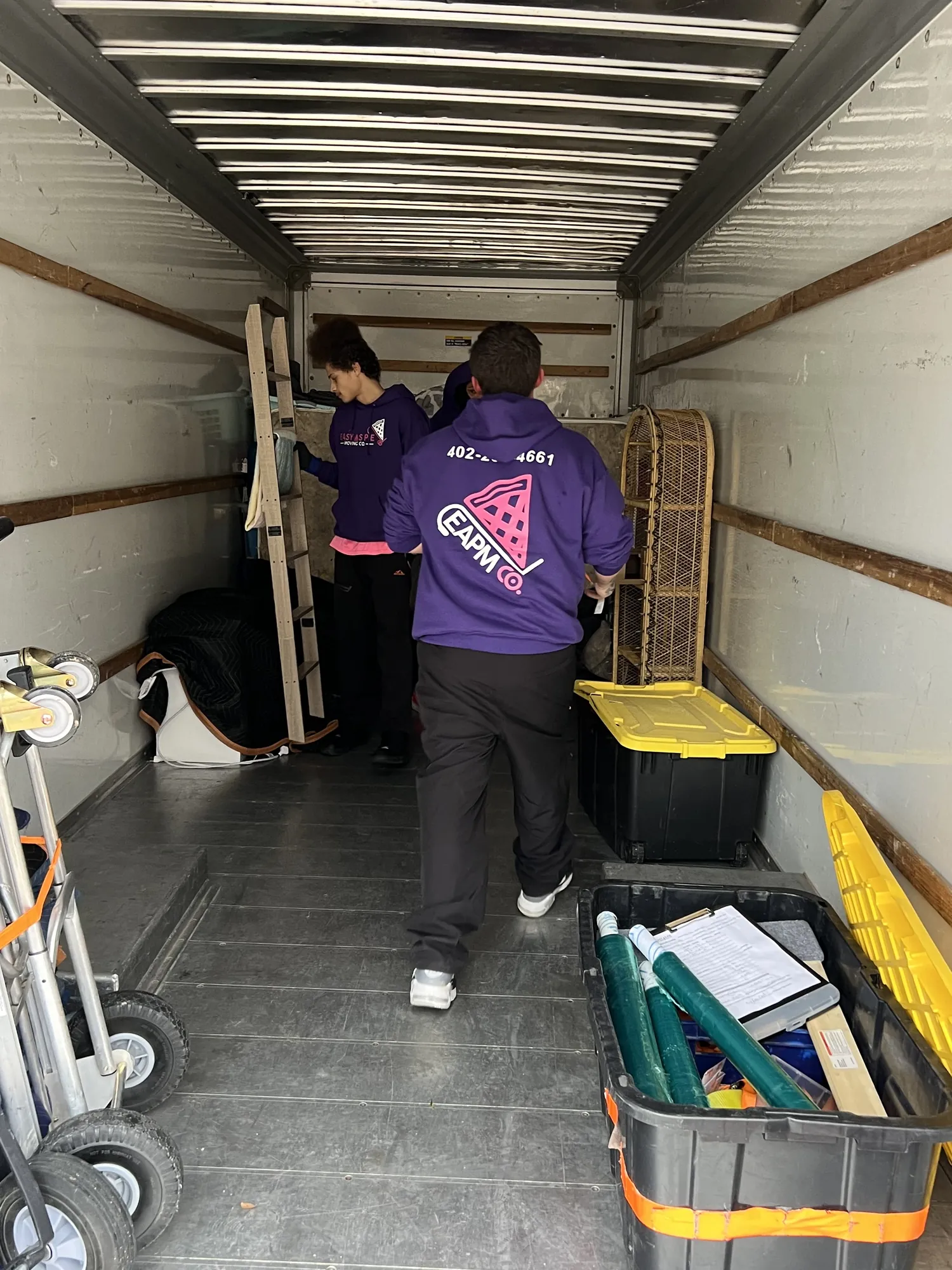Easy As Pie movers loading bins and supplies inside a moving truck