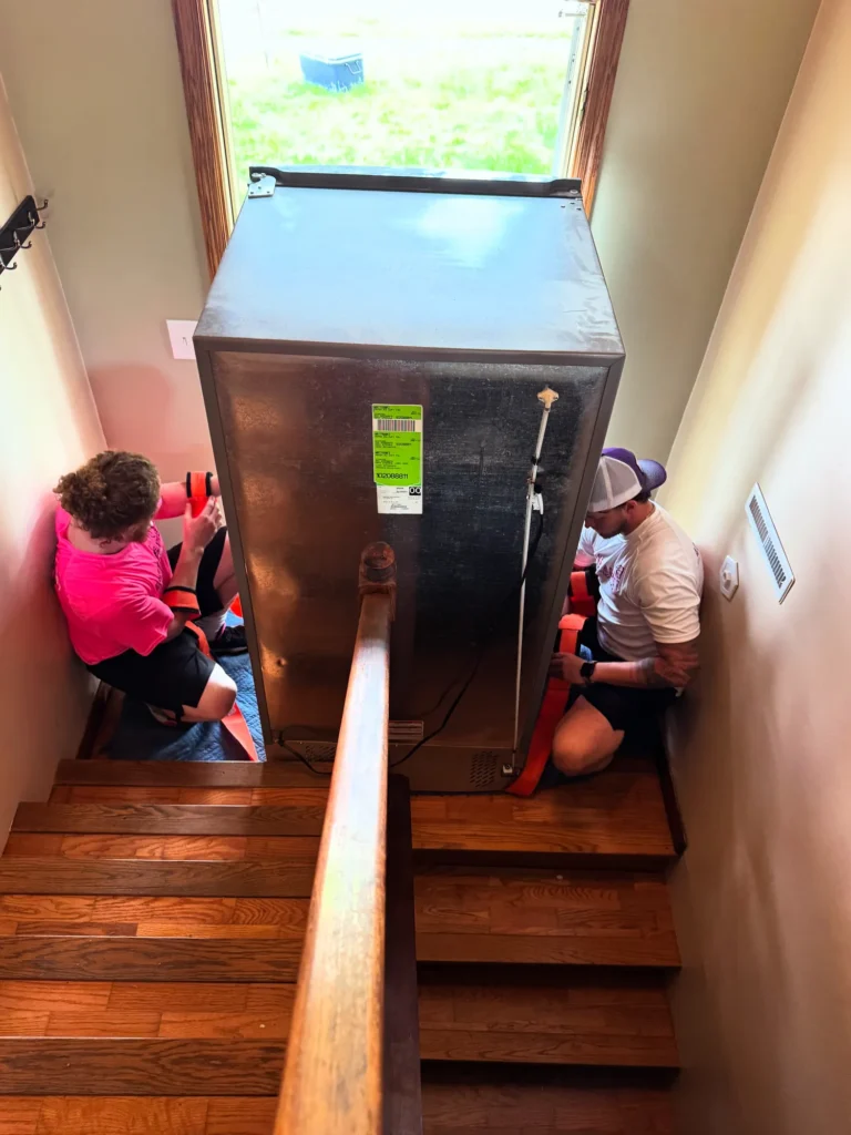 Easy As Pie movers guiding a refrigerator down a staircase