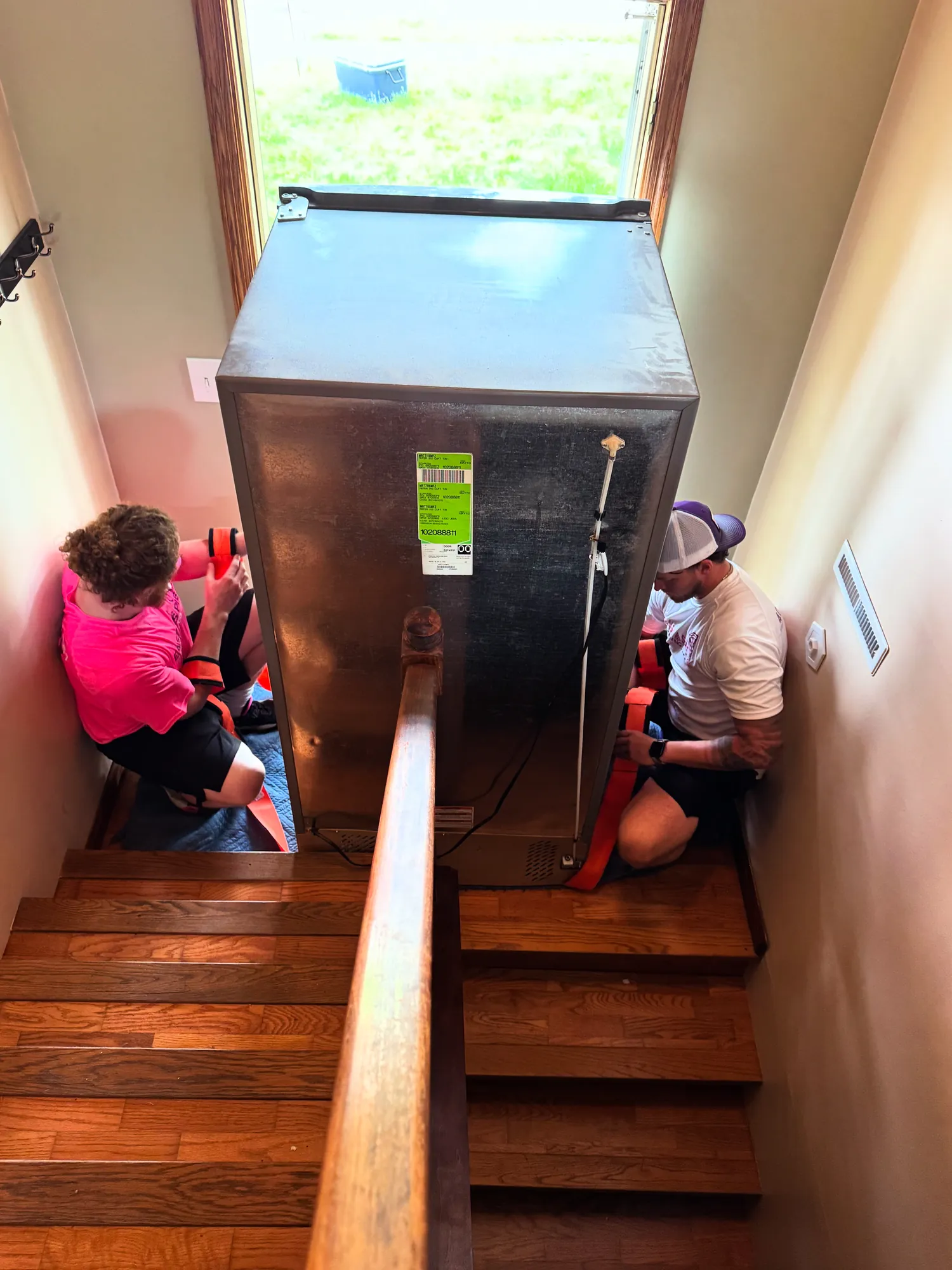 Easy As Pie movers guiding a refrigerator down a staircase