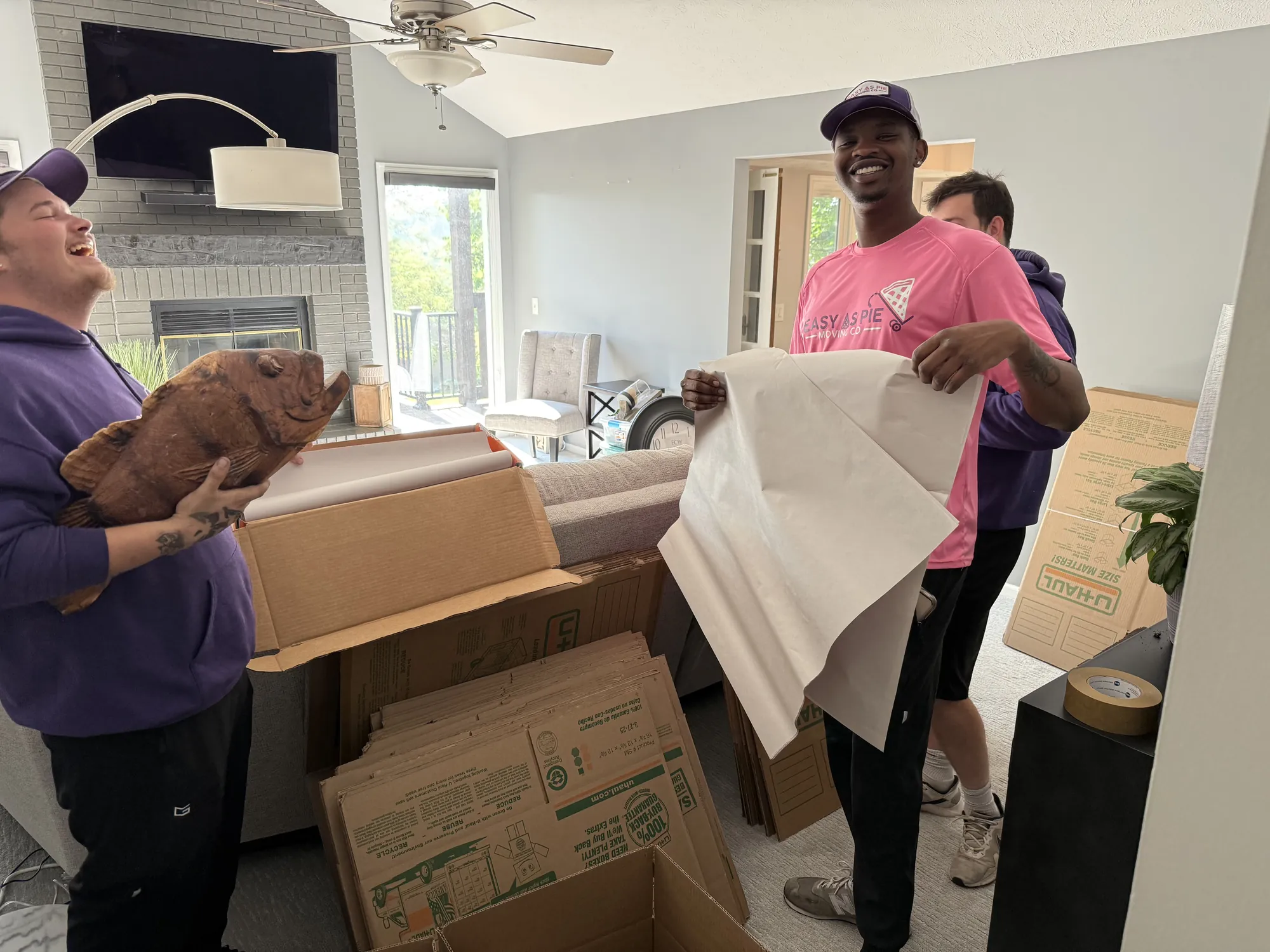 Easy As Pie movers wrapping items in packing paper and filling moving boxes