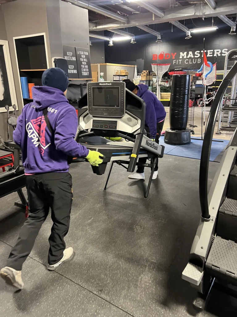 Easy As Pie movers relocating equipment inside a commercial gym