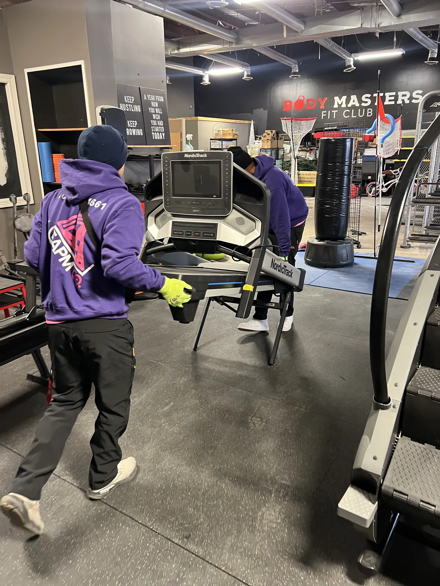 Easy As Pie movers relocating equipment inside a commercial gym