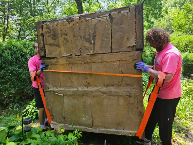 Easy As Pie movers strapping a large piece of furniture outdoors