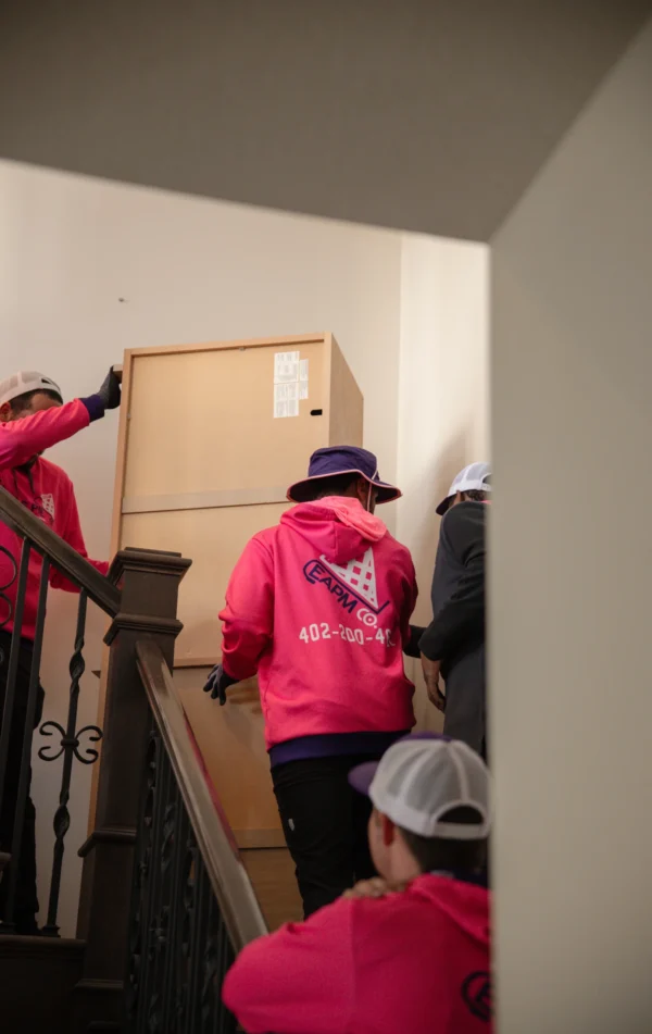 Experienced moving crew transporting heavy furniture safely up stairs in a multi-level condo.