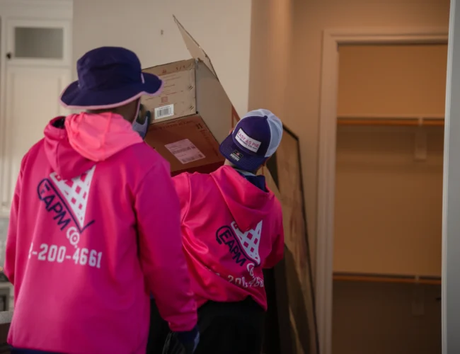 Two movers carrying boxes into a residential home during a Council Bluffs to Omaha move