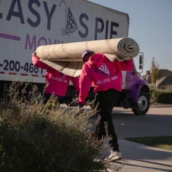 Easy as Pie Omaha movers carrying a large rolled carpet from the truck during a residential move. military movers Omaha